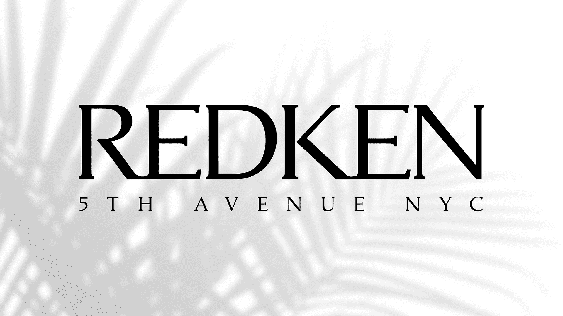 Redken logo with black feather-like design background.