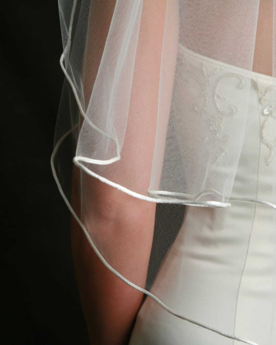 Wedding dress with delicate embroidered veil detail.
